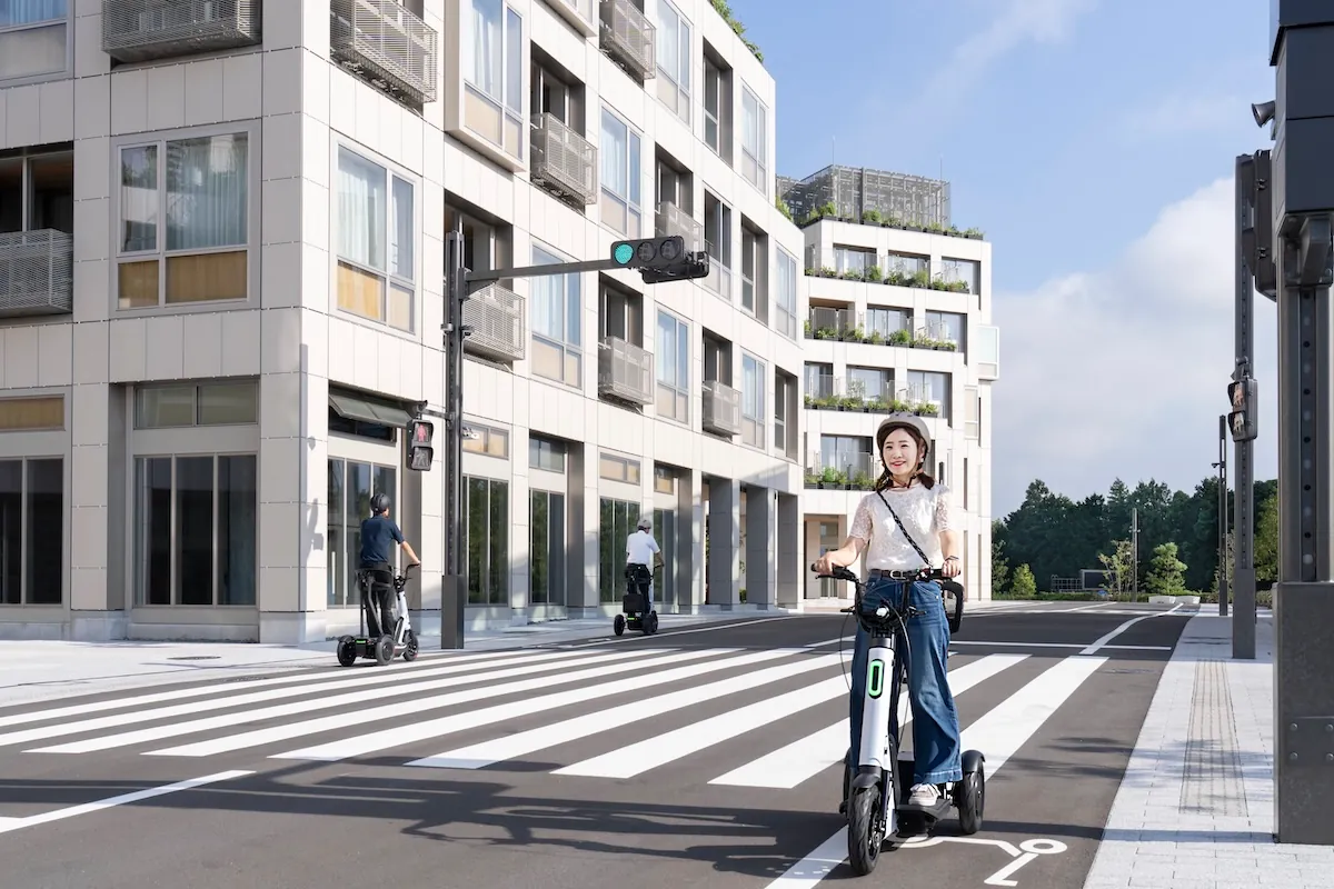 道路をパーソナルモビリティで走行する人の写真。