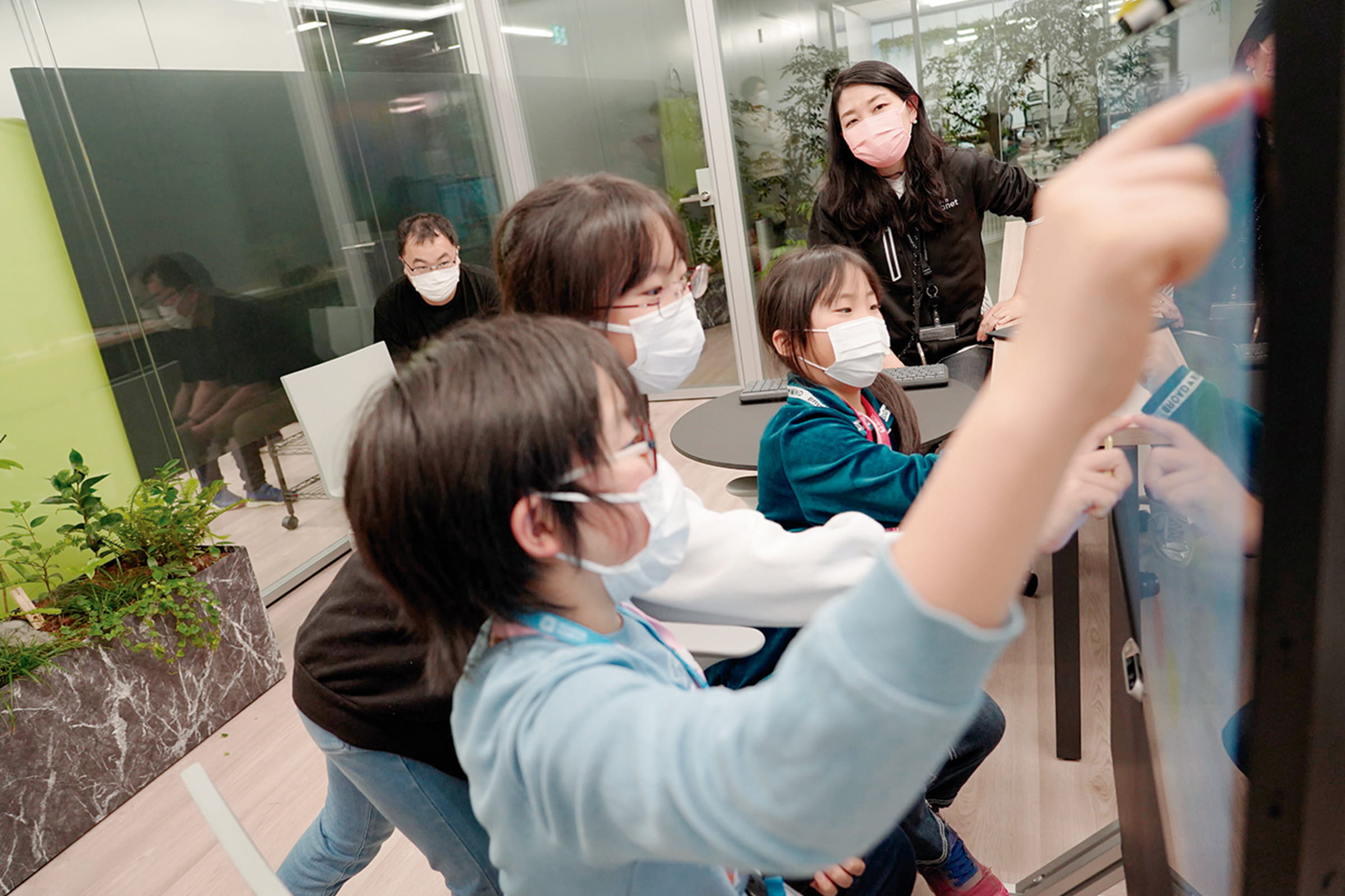 子供たちがオフィスで次世代遠隔コミュニケーションツールを試している様子の写真