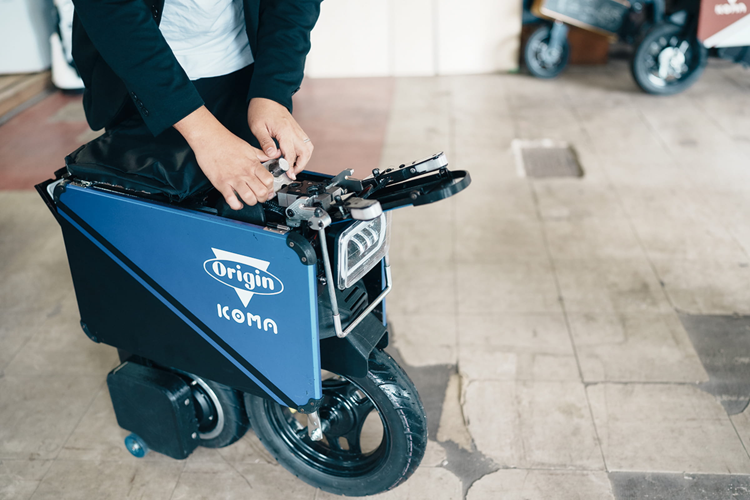 生駒さんがタタメルバイクを畳む様子の写真